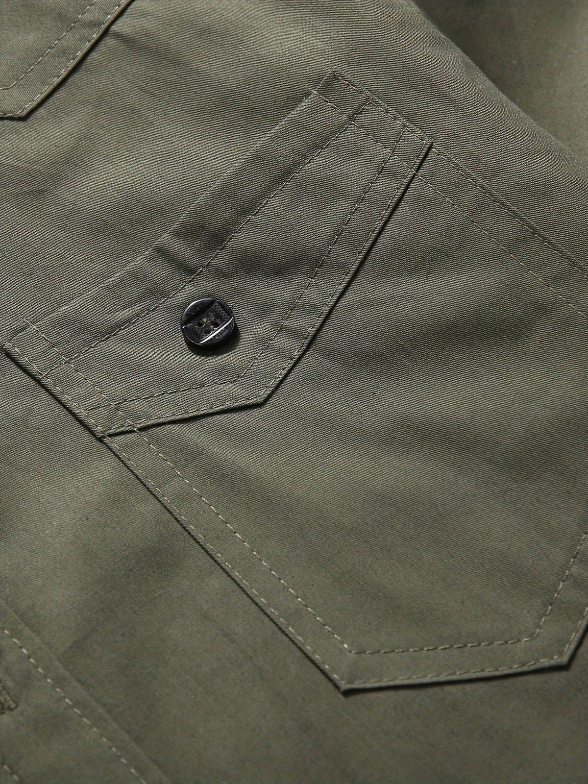 Atmora olive green utility shirt close-up of buttoned flap chest pocket and stitched seam